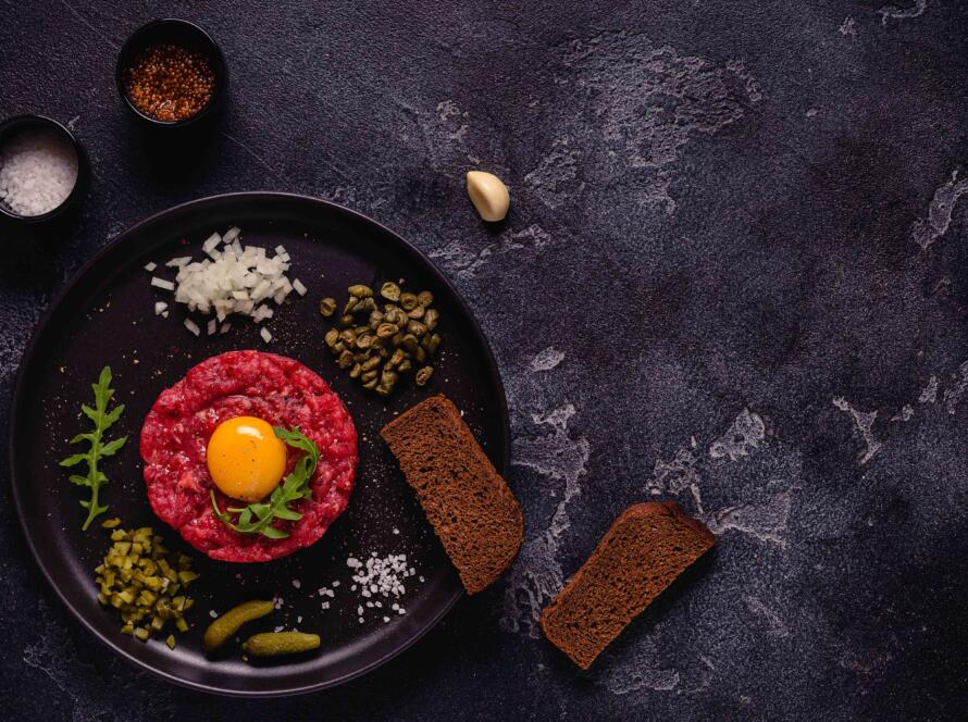 Steak tartar de ternera sobre una tabla negra